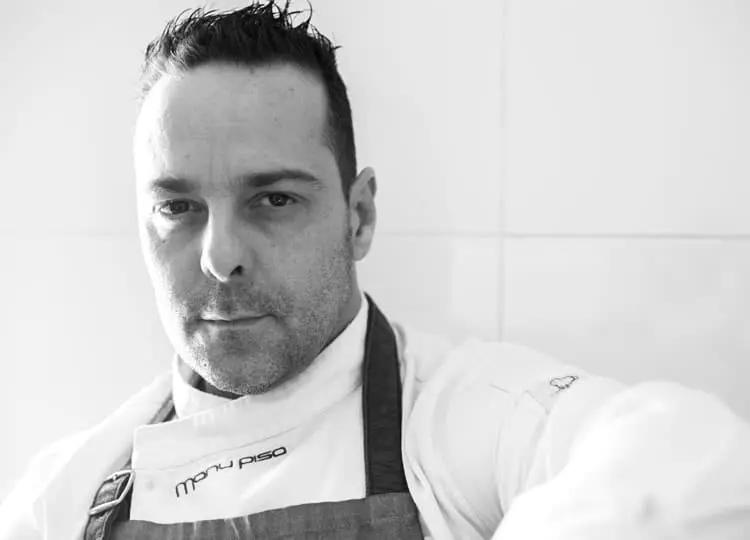 Retrato en blanco y negro del cocinero Manu Pisa, con delantal
